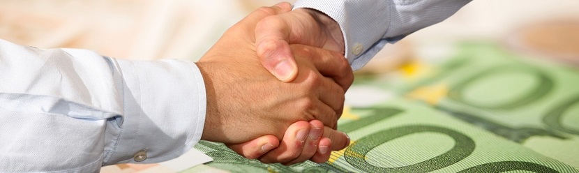 Poignée de mains au dessus de billets euros 