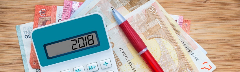  2018 écrit sur une calculatrice et billets euros sur fond en bois