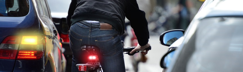un homme sur son vélo en pleine circulation auto 