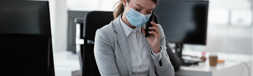  une femme porte un masque au bureau 